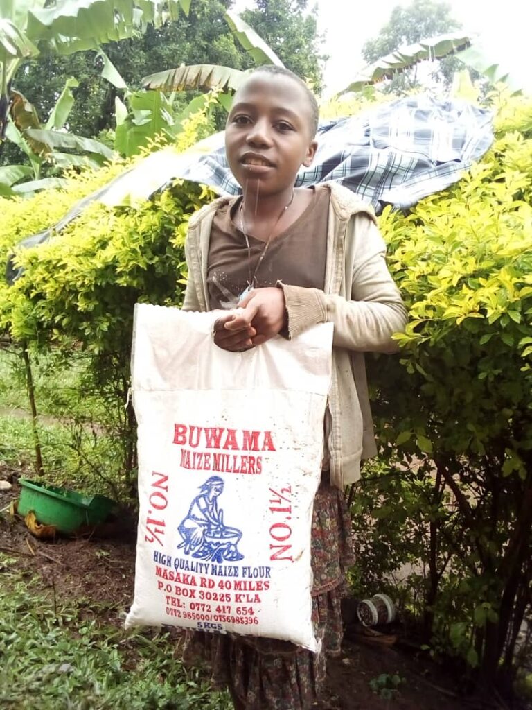 Child in Uganda holding a bag of food